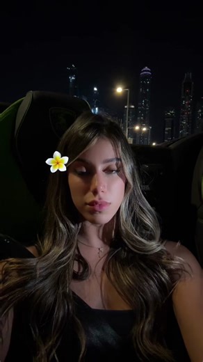 Young Woman Enjoys Night Cityscape from Luxury Car