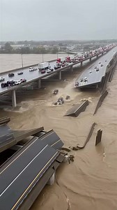 A catastrophic bridge collapse was captured by a wide-angle security camera during a severe flood. The footage shows the center span of the multi-lane freeway buckling before plummeting into the raging river below, carrying several vehicles with it into the turbulent waters. This dramatic incident serves as a stark reminder of the power of nature and the vulnerability of infrastructure. This video is created with AI and the story is for your entertainment. | Michael & Friends