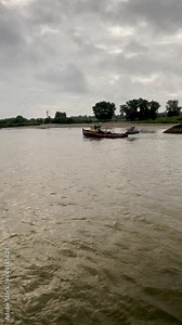 River cruising through South Holland in the Netherlands. Views of Dutch landscape including beaches, green grass and trees. A tug boat passes by view. Located in Gendt, Netherlands on the Waal River.