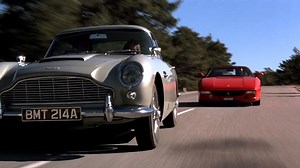 The chase between Bond (Pierce Brosnan) in his Aston Martin DB5 and Onatopp (Famke Janssen) in a Ferrari F355 from GOLDENEYE was filmed on this day in 1995. Legendary stunt driver Rémy Julienne drove the DB5 in the sequence which was filmed at Gréolières-Les-Neiges in France. | James Bond 007